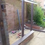 Posts being attached to the dried brick walls